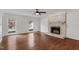 Bright living room with two windows, hardwood floors, and a cozy fireplace feature at 7616 Valley Run Dr, Raleigh, NC 27615