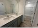 Bathroom with a double sink vanity, neutral gray cabinets, and a view into the shower area at 779 Old Station Pointe, Angier, NC 27501
