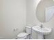 Modern half-bathroom featuring a pedestal sink, round mirror, and a toilet at 779 Old Station Pointe, Angier, NC 27501