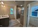 Bathroom featuring double sinks, granite counters, a glass-enclosed shower, and a window at 779 Old Station Pointe, Angier, NC 27501