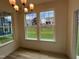 Dining area with chandelier and multiple windows overlooking the green space and neighboring houses at 779 Old Station Pointe, Angier, NC 27501
