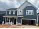New two-story home featuring blue siding, white trim, and an attached two-car garage at 779 Old Station Pointe, Angier, NC 27501