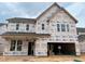 A new two-story home with unfinished exterior featuring a two-car garage and visible construction materials at 779 Old Station Pointe, Angier, NC 27501