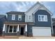 Charming two-story home featuring blue siding, white trim, and a two-car garage at 779 Old Station Pointe, Angier, NC 27501