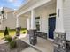 Inviting covered front porch with stone pillar bases and a stylish dark blue front door at 779 Old Station Pointe, Angier, NC 27501