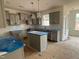 Spacious kitchen with gray cabinets, white backsplash, and an island, awaiting finishing touches at 779 Old Station Pointe, Angier, NC 27501