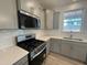 Well-equipped kitchen featuring stainless steel gas range, microwave and sleek countertops at 779 Old Station Pointe, Angier, NC 27501