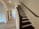 Elegant staircase with dark wood railing and white risers, adding a touch of sophistication at 779 Old Station Pointe, Angier, NC 27501