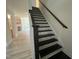 Staircase with dark wood steps and railing with view of the kitchen and hallway at 779 Old Station Pointe, Angier, NC 27501