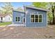 Home exterior featuring blue siding, a patio, and lush, mature trees at 812 East St, Smithfield, NC 27577