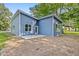 Home exterior featuring blue siding, a patio, and lush, mature trees at 812 East St, Smithfield, NC 27577