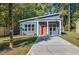 Charming single-story home with blue siding, an orange door, a concrete driveway, and a covered front porch at 812 East St, Smithfield, NC 27577