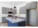 Modern kitchen featuring gray cabinets, stainless steel appliances, and a center island with pendant lights at 812 East St, Smithfield, NC 27577