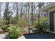 Landscaped backyard featuring a quaint wooden gate, lush greenery, and pebble pathway through the trees at 817 Old Mill Rd, Chapel Hill, NC 27514
