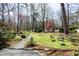Spacious backyard featuring a stone pathway, mature trees, a lush lawn, and outdoor seating at 817 Old Mill Rd, Chapel Hill, NC 27514