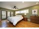 Spacious bedroom with hardwood floors, ceiling fan, and access to a private outdoor area at 817 Old Mill Rd, Chapel Hill, NC 27514