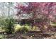 Landscaped front exterior with flowering trees, blooming daffodils, and a gray brick home at 817 Old Mill Rd, Chapel Hill, NC 27514
