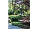 Beautifully landscaped yard with mature trees, a stone pathway, and lush greenery at 817 Old Mill Rd, Chapel Hill, NC 27514