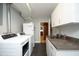 Bright laundry room with modern washer and dryer, granite counters, and plenty of storage space at 817 Old Mill Rd, Chapel Hill, NC 27514