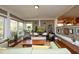 Cozy living room featuring large windows, a fireplace, and a view into the kitchen at 817 Old Mill Rd, Chapel Hill, NC 27514
