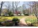 Brick pathway leading to a home surrounded by landscaping, flowers, and mature trees at 817 Old Mill Rd, Chapel Hill, NC 27514