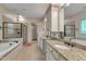 Luxurious bathroom with a jacuzzi tub, walk-in shower, and dual granite vanity at 85 Christenbury Ln, Clayton, NC 27527