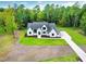 Aerial view of a modern two-story home with a large lot, manicured lawn, and a long driveway at 92 Bluffside Ct, Pittsboro, NC 27312