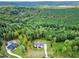 Aerial view of a luxury home in a wooded, secluded setting with a pool at 92 Bluffside Ct, Pittsboro, NC 27312