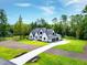 Aerial view of a two-story home featuring a three-car garage, long driveway, and a spacious landscaped lot at 92 Bluffside Ct, Pittsboro, NC 27312