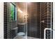 Contemporary tiled shower with glass enclosure, modern fixtures, and a window offering natural light and views at 92 Bluffside Ct, Pittsboro, NC 27312