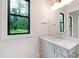 Modern bathroom with marble countertop, sleek fixtures, and a large window for natural light and scenic views at 92 Bluffside Ct, Pittsboro, NC 27312