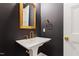 Elegant powder room with dark walls, gold accents, and a pedestal sink at 92 Bluffside Ct, Pittsboro, NC 27312