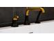 A modern, black and gold bathtub faucet is installed on a white tub against dark tile at 92 Bluffside Ct, Pittsboro, NC 27312