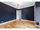 Stylish bedroom with bold navy walls, hardwood floors, and modern lighting creates a sophisticated atmosphere at 92 Bluffside Ct, Pittsboro, NC 27312