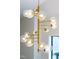 Close-up of a modern chandelier with glass globes and brass finish, adding elegance and style to the interior at 92 Bluffside Ct, Pittsboro, NC 27312