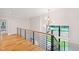 Bright hallway features hardwood floors, modern railing, and stylish lighting fixture at 92 Bluffside Ct, Pittsboro, NC 27312