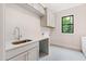 Well-lit laundry room with shaker cabinets, quartz countertop, and tiled floor at 92 Bluffside Ct, Pittsboro, NC 27312