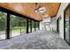 Covered porch featuring stone floors, wood ceiling with skylights, and outdoor stainless steel kitchen and barbecue at 92 Bluffside Ct, Pittsboro, NC 27312