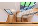 Modern staircase with hardwood steps, black metal railings, and large windows for natural light and outdoor views at 92 Bluffside Ct, Pittsboro, NC 27312