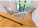 Elegant staircase with hardwood steps, modern metal railing, and large windows offering abundant natural light at 92 Bluffside Ct, Pittsboro, NC 27312