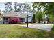 Spacious backyard featuring a basketball court, manicured lawn, screened porch, and vibrant pink landscaping at 101 Goldenthal Ct, Cary, NC 27519