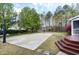 Backyard with a basketball court, wooden deck with stairs, screened porch and lush green surroundings at 101 Goldenthal Ct, Cary, NC 27519
