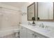 Bright bathroom features double sink vanity and tub with shower and neutral color palette at 101 Goldenthal Ct, Cary, NC 27519