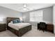 Comfortable bedroom with a ceiling fan, a bed with blue throw pillows, and a built-in desk at 101 Goldenthal Ct, Cary, NC 27519