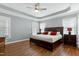 Spacious bedroom boasts a large bed, hardwood floors, a ceiling fan, and bright natural light at 101 Goldenthal Ct, Cary, NC 27519
