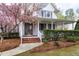 Inviting home entrance featuring a covered front porch, brick steps and blossoming tree at 101 Goldenthal Ct, Cary, NC 27519