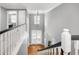 Elegant hallway with hardwood floors, white banisters, and an open view of the entryway below at 101 Goldenthal Ct, Cary, NC 27519