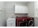 Well-organized laundry room with storage cabinets, sink and modern washer and dryer units at 101 Goldenthal Ct, Cary, NC 27519
