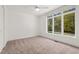 Carpeted bedroom with large windows, neutral colors, and a closet at 1021 Reaves Dr Dr, Chapel Hill, NC 27516
