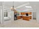Open kitchen with oak cabinetry, stainless steel appliances, and views to the sunroom at 1021 Reaves Dr Dr, Chapel Hill, NC 27516